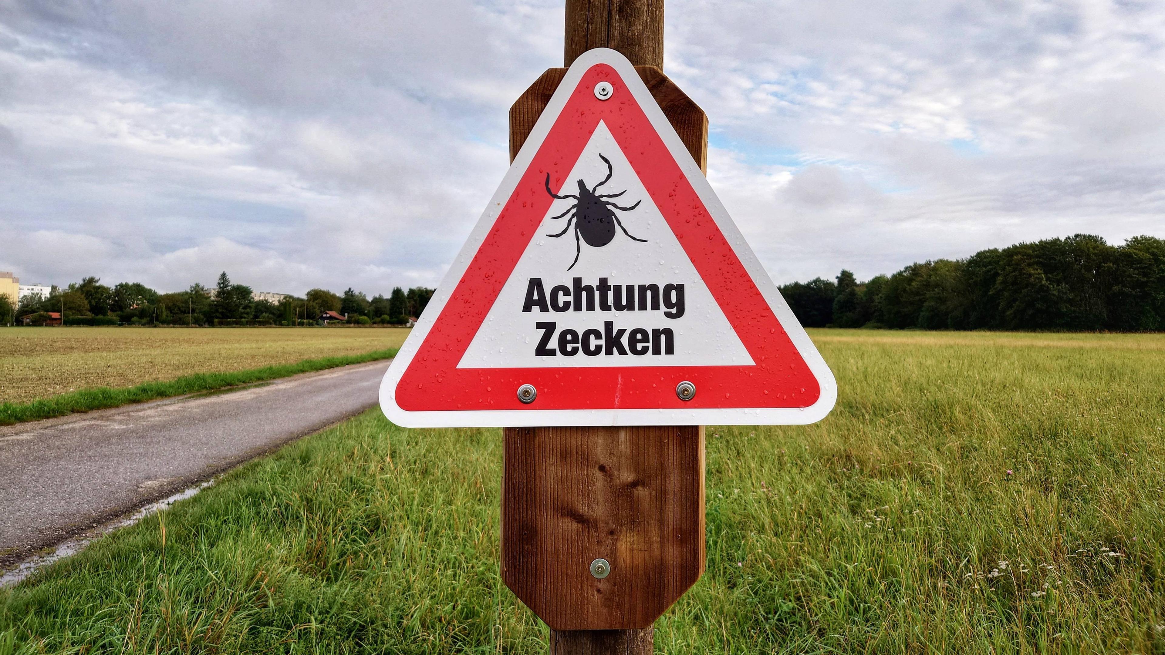Zecken-Warnschild auf einer Wiese