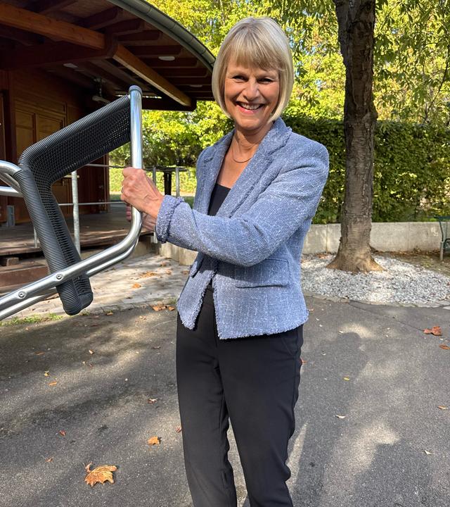Gundula Gause hält einen Stuhl.