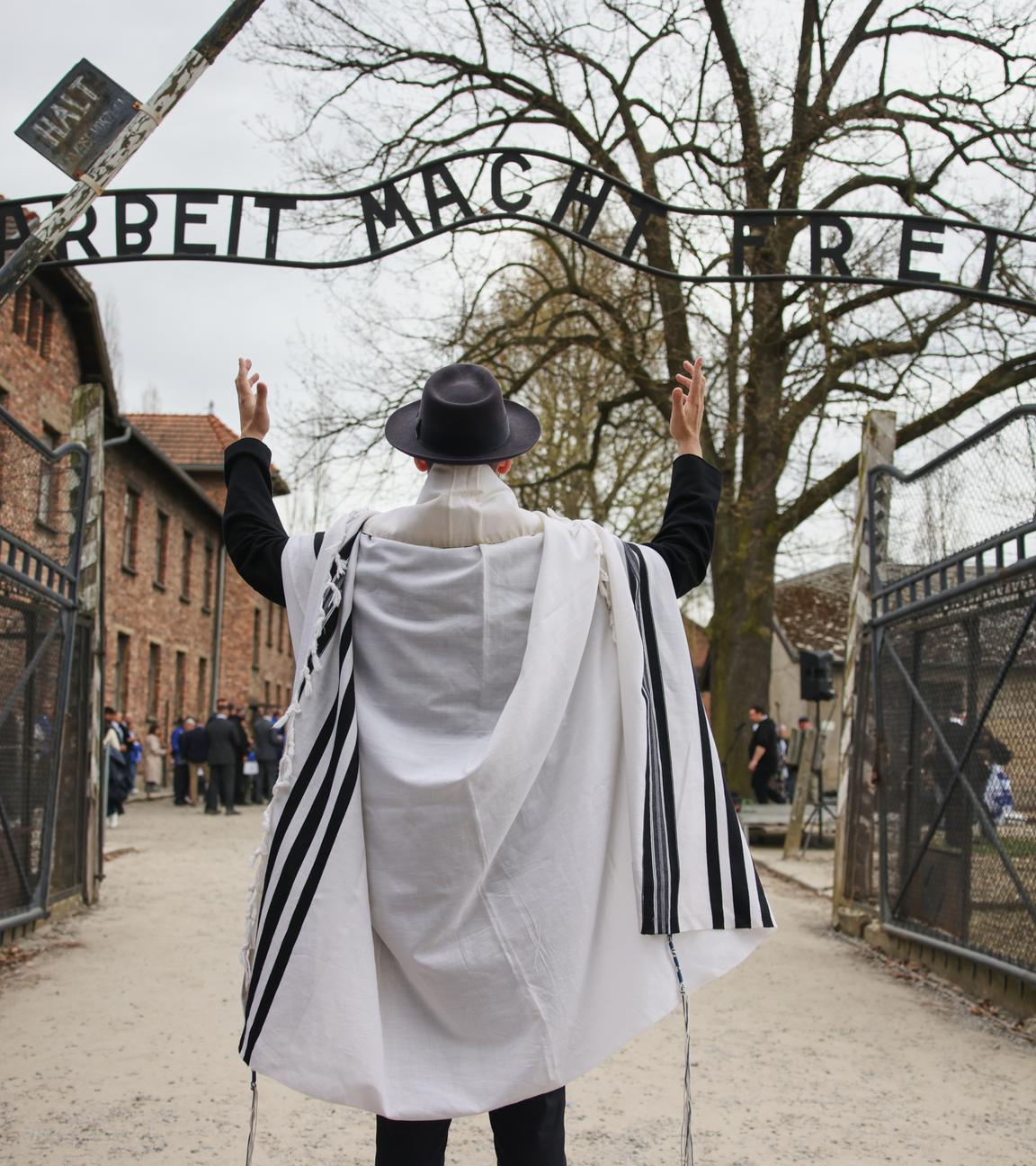 Ein Mann steht vor dem Eingang von Auschwitz zum jährlichen "Marsch der Lebenden", einem jährlichen Gedenkmarsch zwischen den ehemaligen Vernichtungslagern Auschwitz und Birkenau