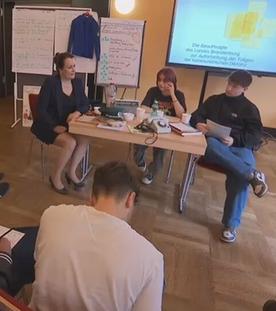 Menschen sitzen gemeinsam in einem Zeitzeugen-Workshop über die DDR-Zeit und Wiedervereinigung.