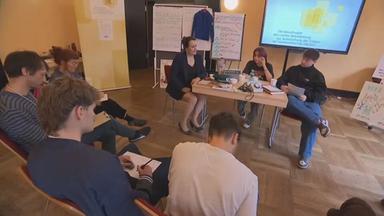Menschen sitzen gemeinsam in einem Zeitzeugen-Workshop über die DDR-Zeit und Wiedervereinigung.