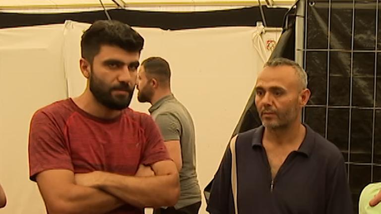 Zu sehen sind Geflüchtete in einem Zeltlager in Bensheim.