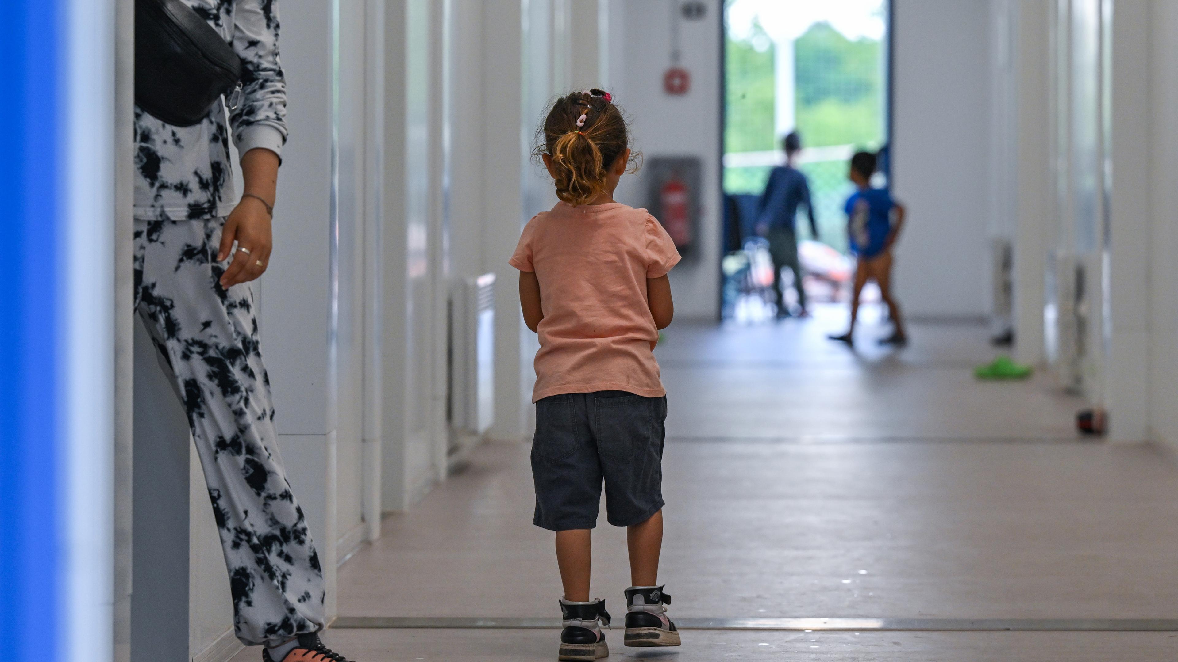 Ein kleines Mädchen steht auf dem Flur von Wohncontainern für Migranten auf dem Gelände der Zentralen Erstaufnahmeeinrichtung für Asylbewerber (ZABH) des Landes Brandenburg. 