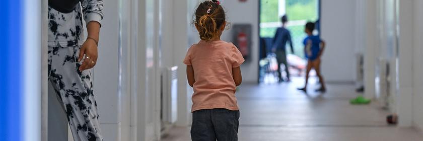 Ein kleines Mädchen steht auf dem Flur von Wohncontainern für Migranten auf dem Gelände der Zentralen Erstaufnahmeeinrichtung für Asylbewerber (ZABH) des Landes Brandenburg. 