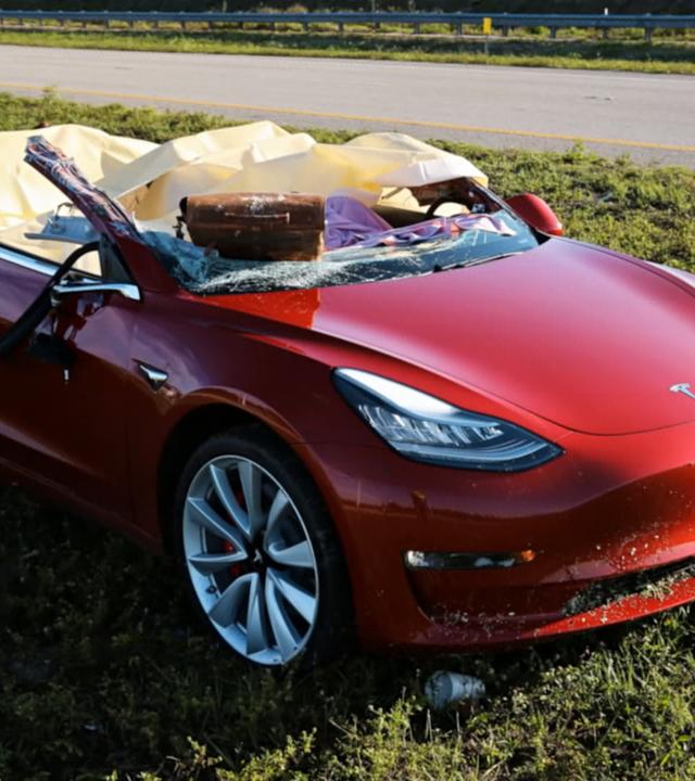 Zerstörtes Tesla-Fahrzeug nach Unfall auf Landstraße, Wagendach nicht mehr vorhanden