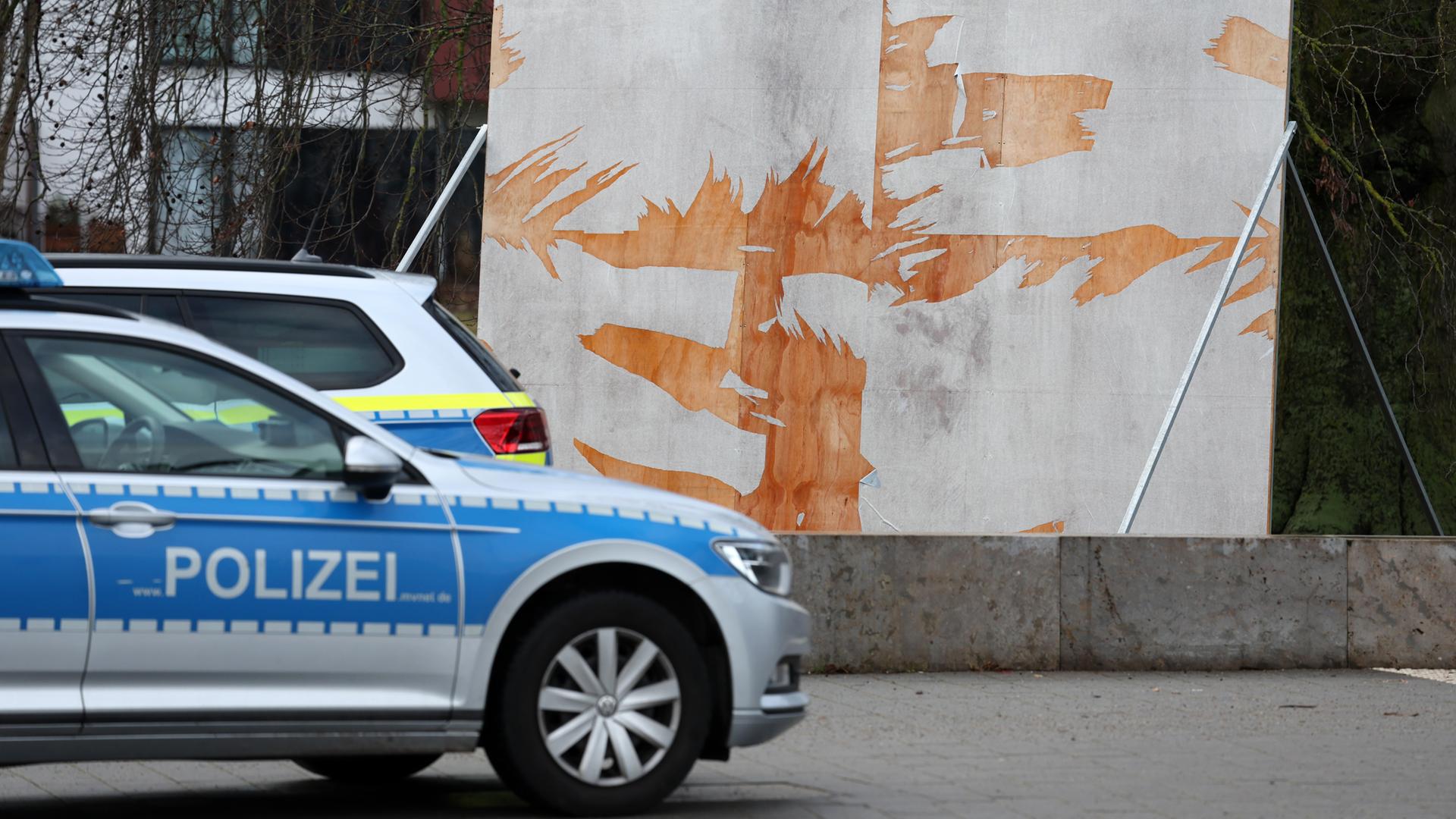 Mecklenburg-Vorpommern, Rostock: Ein Polizeiauto steht vor einem zerstörten Wahlplakat in der Innenstadt.