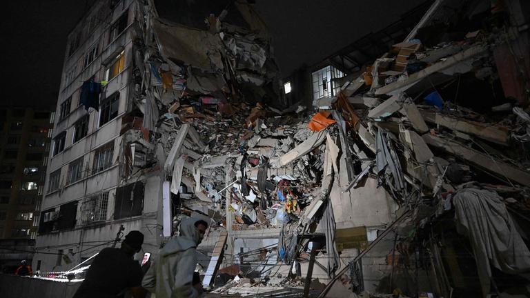 Menschen betrachten ein eingestürztes Gebäude im Stadtviertel Altamira nach einem Erdbeben in Caracas am 24. Juni 2026. 