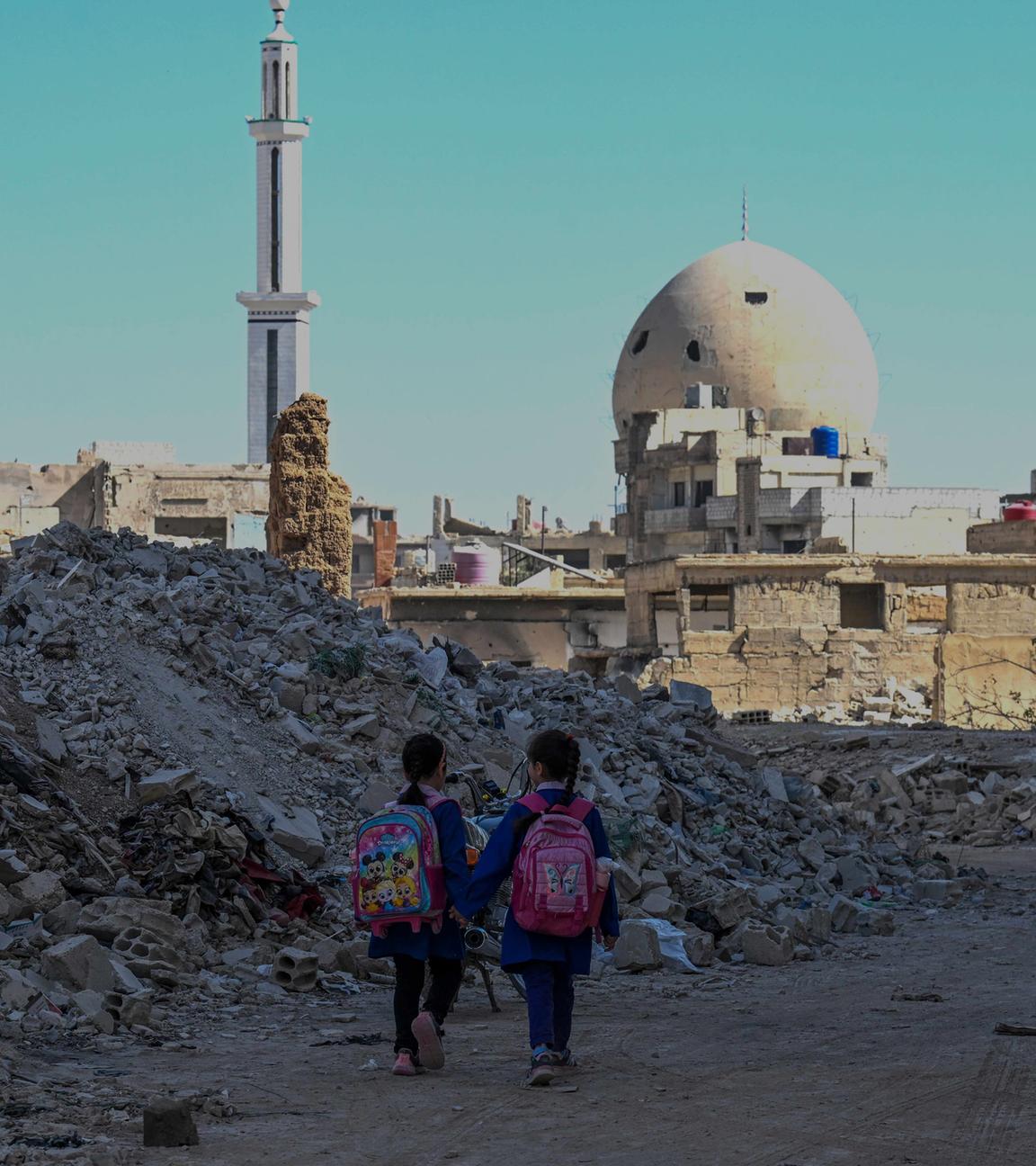 Syrische Kinder laufen am 29. 10. 2025 durch die Trümmer zerstörter Gebäude in Daraya am Stadtrand von Damaskus. 