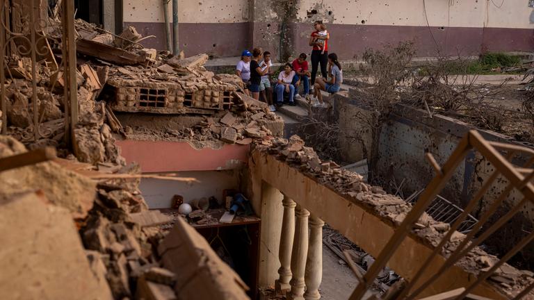 Menschen betrachten ein durch einen Sprengsatz beschädigtes Gebäude in Catia La Mar, Venezuela, am 04.01. 2026. 