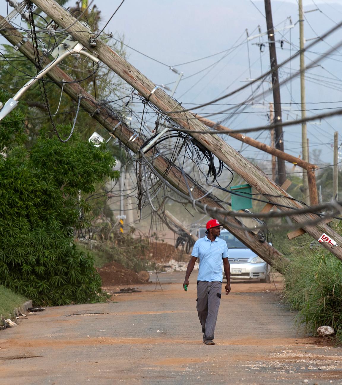 Eine Person geht  in Santa Cruz, Jamaika eine Straße entlang, die vom Hurrikan Melissa betroffen ist.
