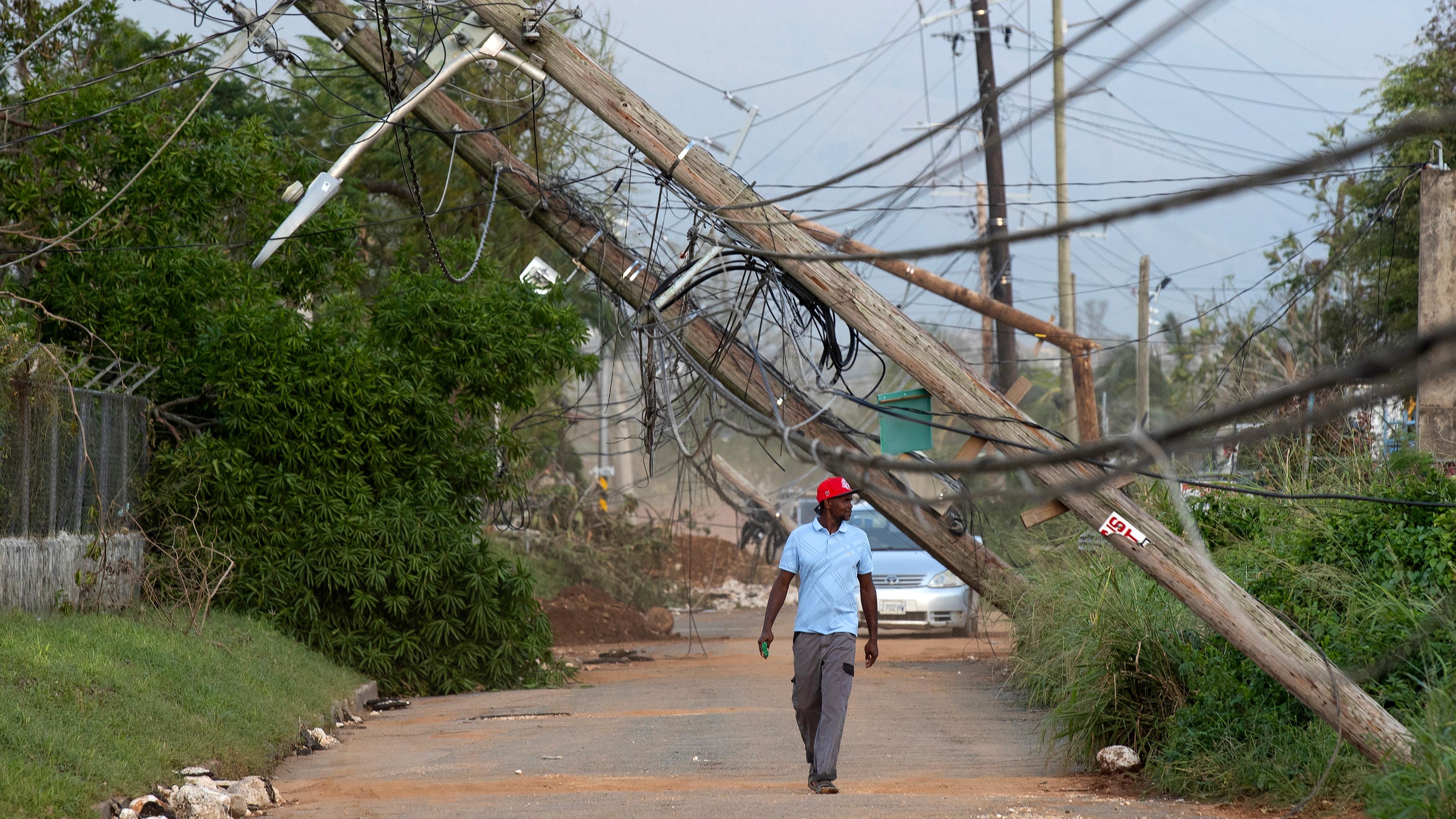 Eine Person geht  in Santa Cruz, Jamaika eine Straße entlang, die vom Hurrikan Melissa betroffen ist.