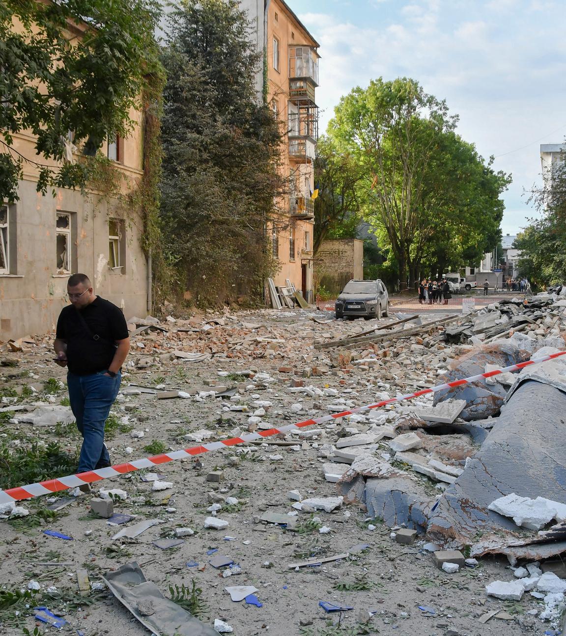 Menschen gehen am Ort eines russischen Angriffs auf ein Wohngebiet in Lwiw (Ukraine) vorbei, nachdem es am 21. 8. 2025 zu einem massiven Angriff in der Nacht gekommen war. 