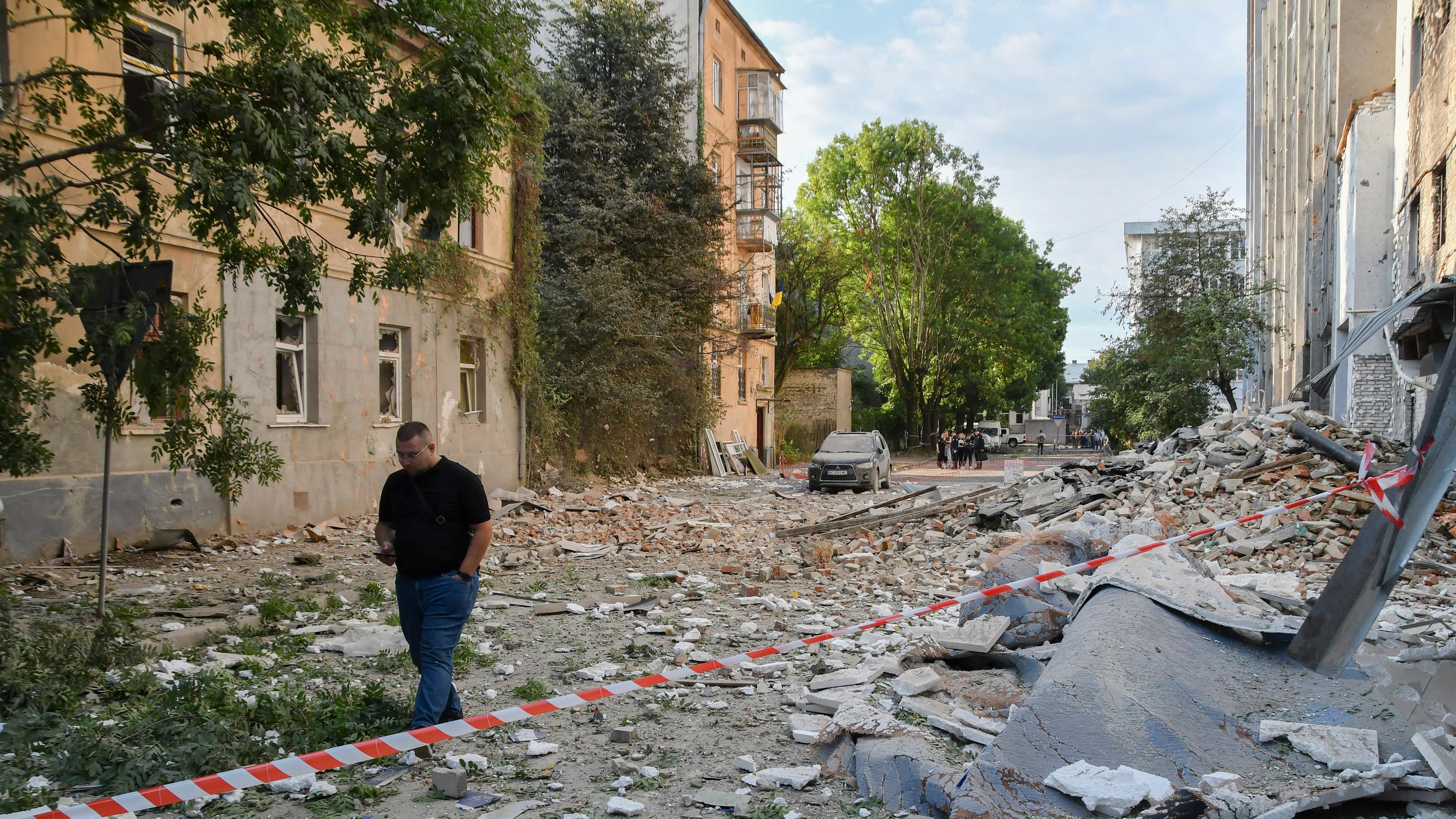Menschen gehen am Ort eines russischen Angriffs auf ein Wohngebiet in Lwiw (Ukraine) vorbei, nachdem es am 21. 8. 2025 zu einem massiven Angriff in der Nacht gekommen war. 