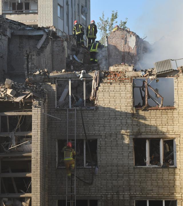 30.07.2026, Ukraine, Lemberg: Rettungskräfte durchsuchen nach einem Luftangriff in Lemberg (Ukraine) die Trümmer eines Wohngebäudes.