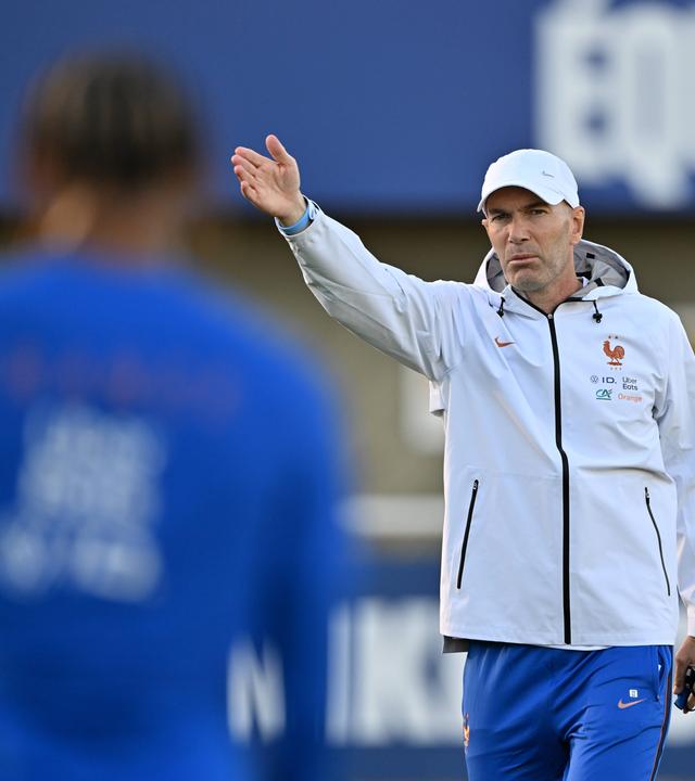 Französischer Nationaltrainer mit weisser Jacke und Kappe instruiert seine Spieler