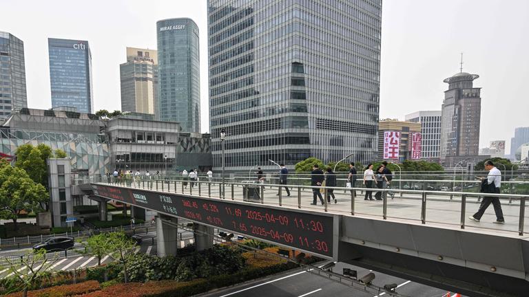 Shanghai, China: Menschen laufen zu Fuß über eine Brücke.