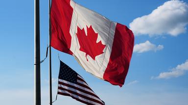 Nationalflaggen Kanadas und der USA wehen im Wind