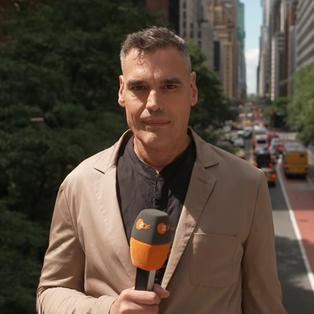 ZDF-Korrespondent Armin Coerper in New York bei Tageslicht. Im Hintergrund sieht man eine befahrene Straße