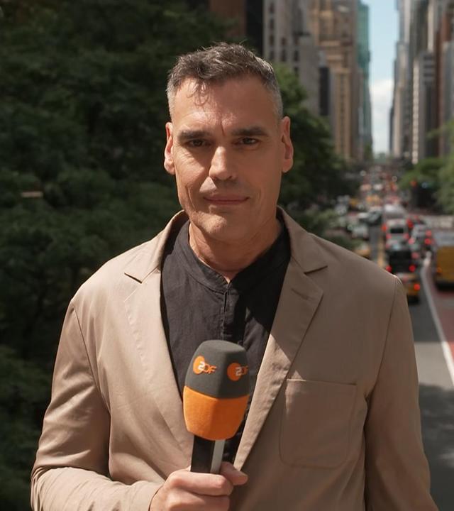 ZDF-Korrespondent Armin Coerper in New York bei Tageslicht. Im Hintergrund sieht man eine befahrene Straße