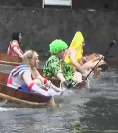 In Fluss paddeln verkleidete Menschen in Waschzubbern um die Wette
