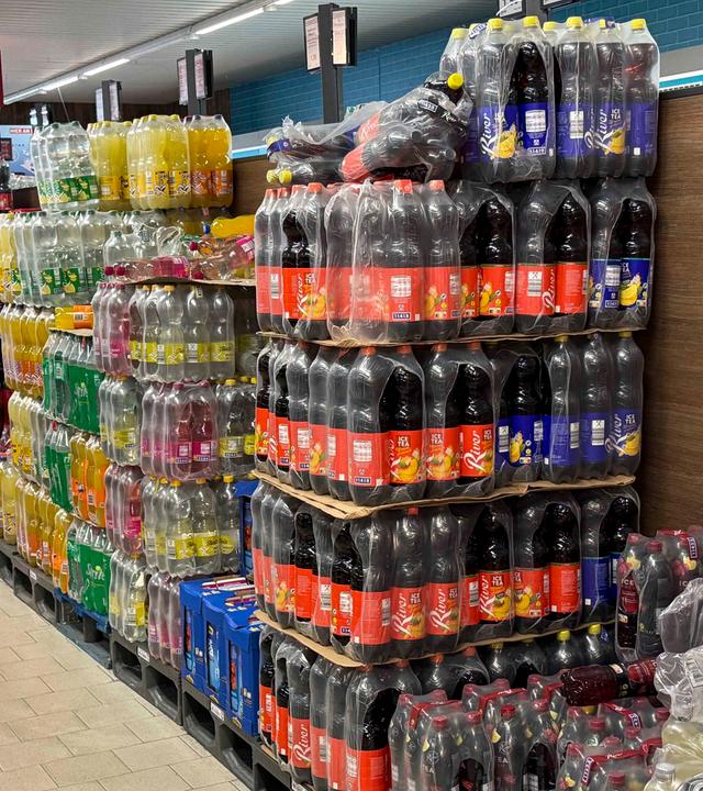 Diverse Sorten Bunte Brause Cola Saftflachen Limonade in Plastik Flaschen Plastik verpackung auf Paletten in einem Aldi Nord Discounter zum Verkauf