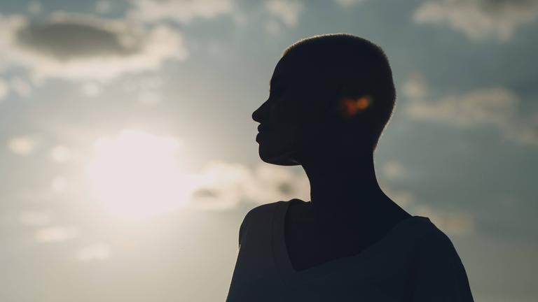 Silhouette einer jungen, lächelnden Frau.