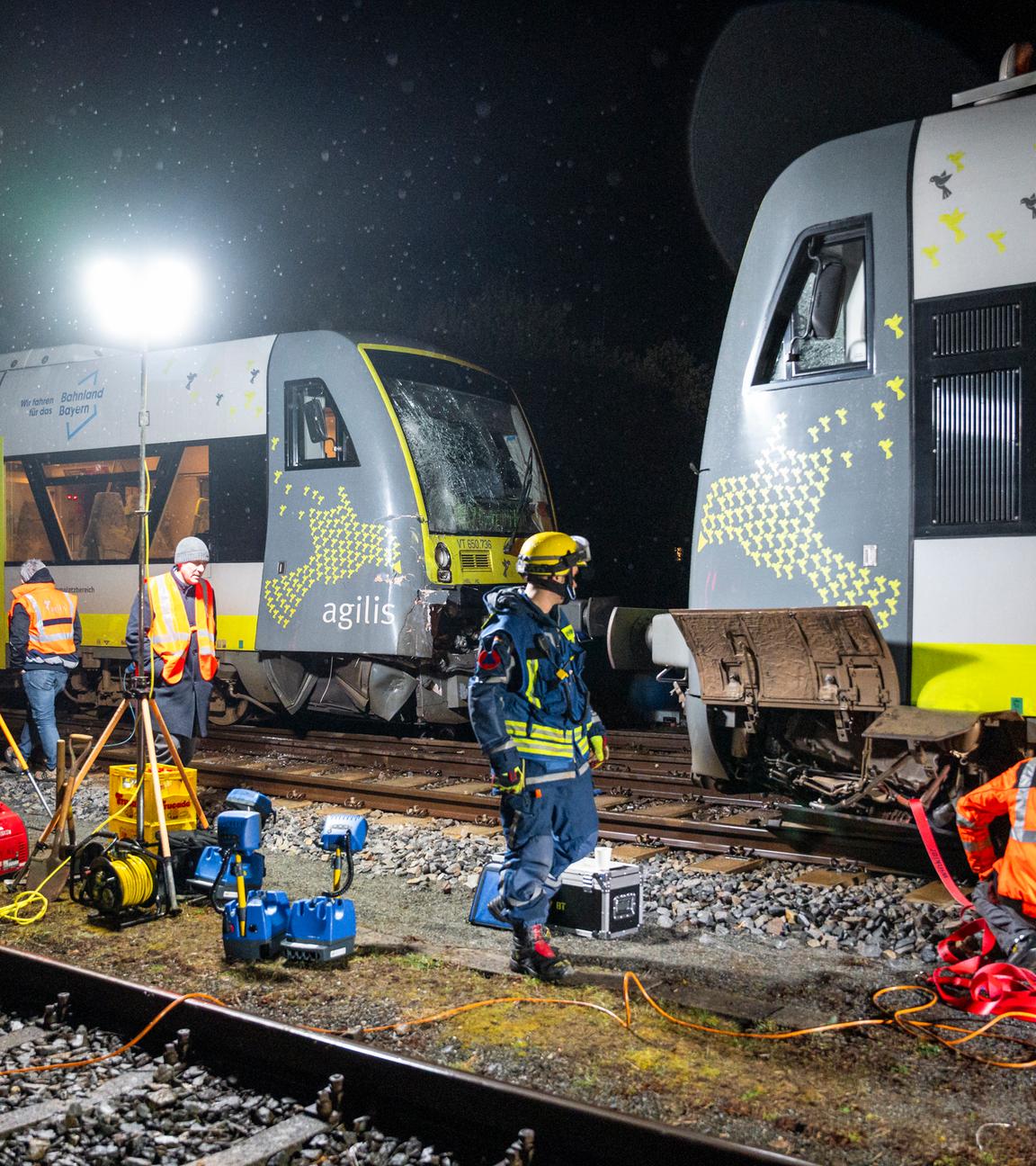 Einsatzkräfte des THW und der Agilis Verkehrsgesellschaft führen Arbeiten an den kollidierten Zügen aus, damit diese von den Gleisen abtransportiert werden können. 