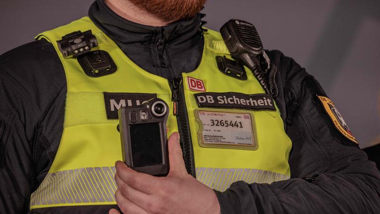Ein Mitarbeiter der DB Sicherheit zeigt eine Bodycam nach einer Pressekonferenz der Deutschen Bahn.