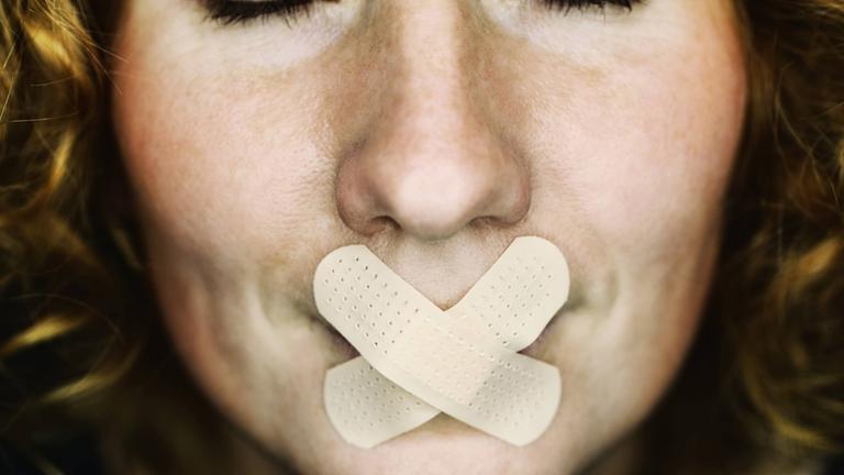 Symbolfoto: Frau mit Pflaster auf dem Mund 