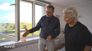 Ein Energieberater testet Abdichtungen am Fenster, um Zugluft zu verhinern.