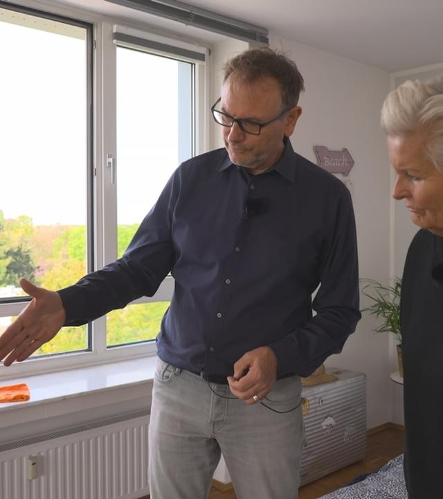 Ein Energieberater testet Abdichtungen am Fenster, um Zugluft zu verhinern.
