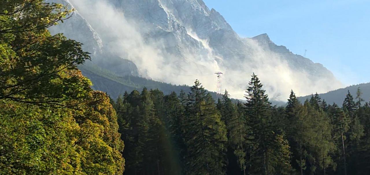 Eine große Staubwolke ist an der Zugspitze zu sehen, nachdem sich am Grenzkamm mehrere Kubikmeter Felsen gelöst haben.