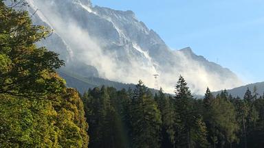 Eine große Staubwolke ist an der Zugspitze zu sehen, nachdem sich am Grenzkamm mehrere Kubikmeter Felsen gelöst haben.