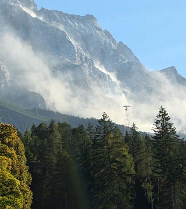 Eine große Staubwolke ist an der Zugspitze zu sehen, nachdem sich am Grenzkamm mehrere Kubikmeter Felsen gelöst haben.