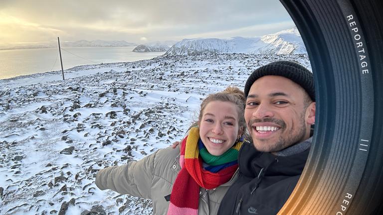 Henni und Cedric posieren an einem verschneiten Strand für ein Selfie.