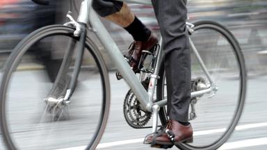 Ein Fahrradfahrer mit Anzug fährt durch München.