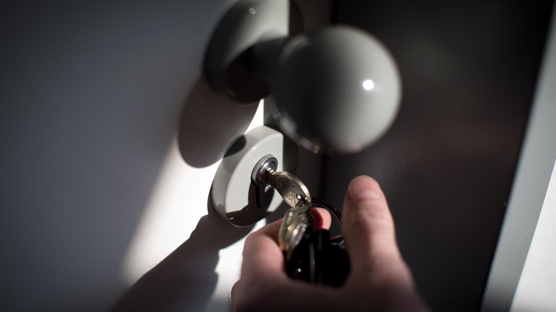 In einer Tür, die geöffnet wird steckt ein Schlüssel.