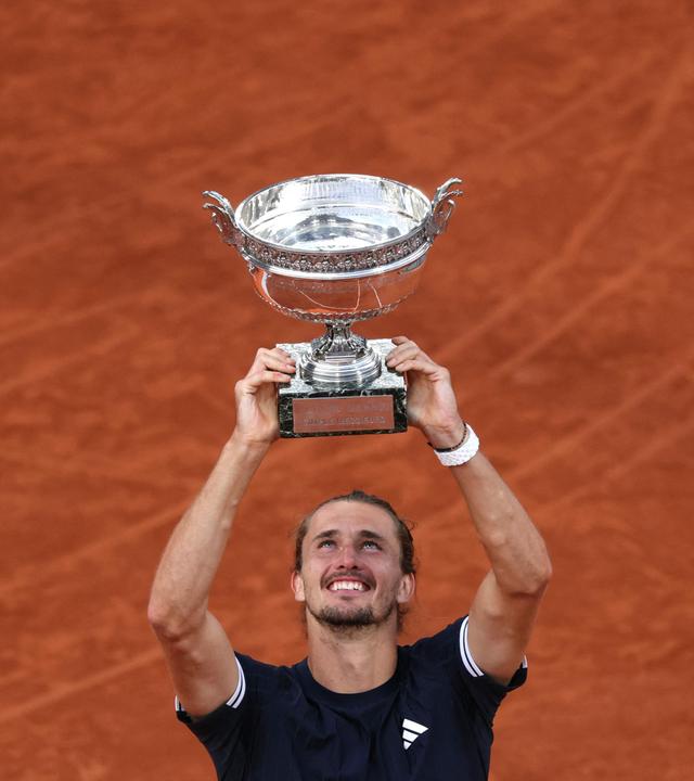 Alexander Zverev hält den "Coupe des Mousquetaires" und feiert seinen Sieg bei den French Open.