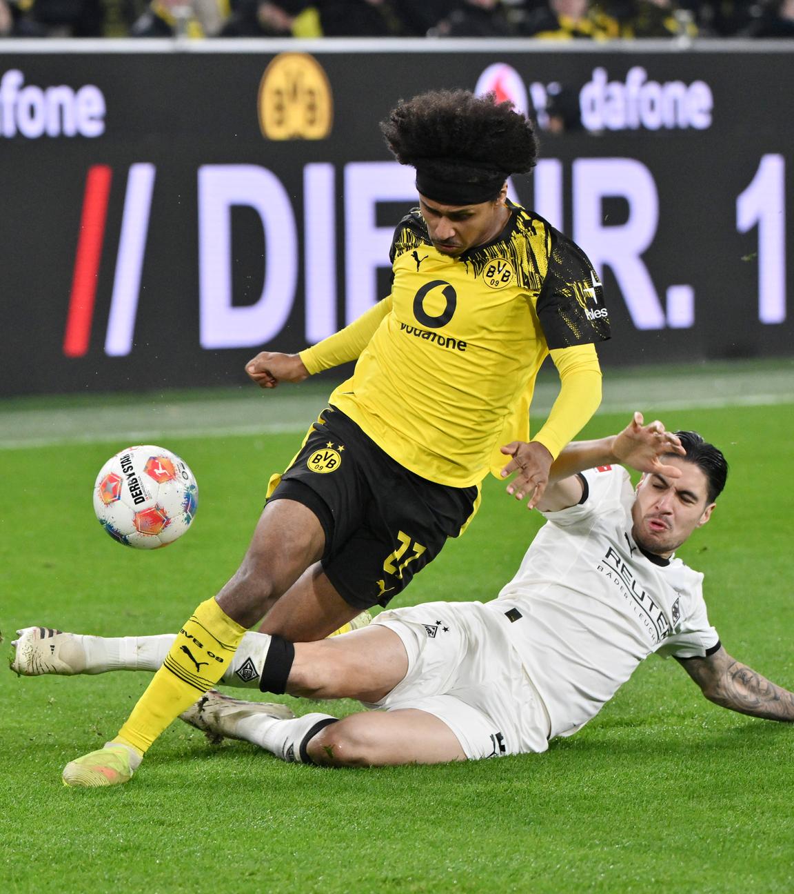 Mönchengladbachs Kevin Diks grätscht im Zweikampf Dortmunds Karim Adeyemi samt Ball um.