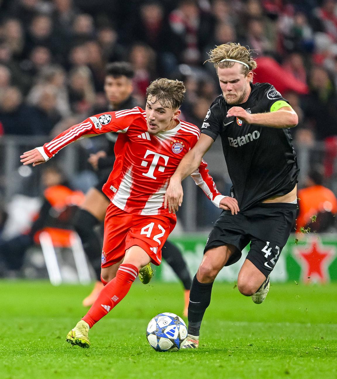 Im Championsleaguespiel des FC Bayern München gegen Sporting Lissabon kämpfen Bayerns Lennart Karl und Sportings Morteb Hjulmand um den Ball.