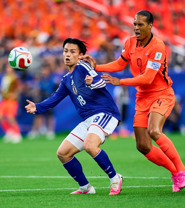 Der niederländische Nationalspieler Virgil van Dijk und sein japanische Kontrahent Ayase Ueda kämpfen in der WM-Partie um den Ball