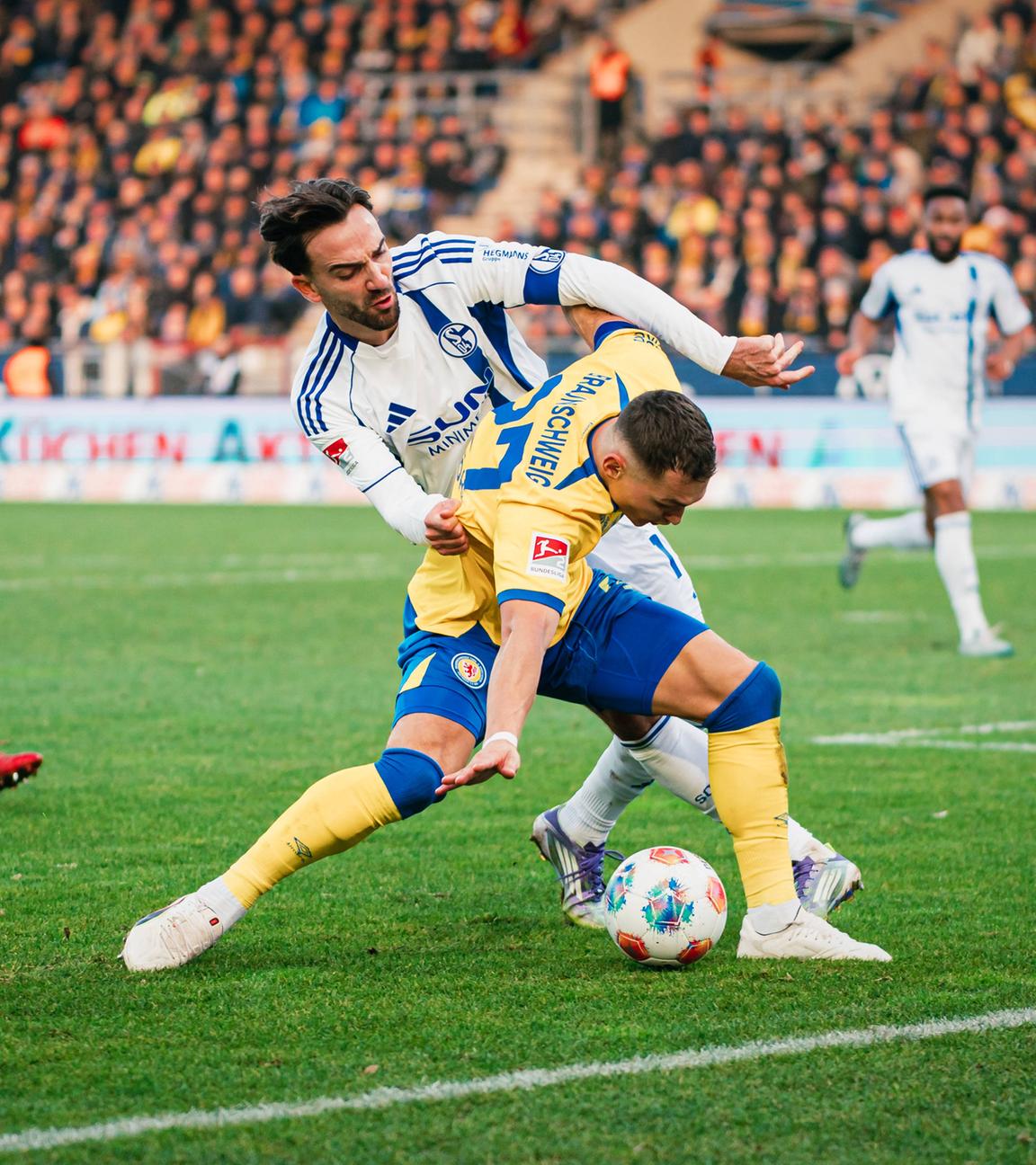 Braunschweigs Fabio Di Michele Sánchez wird in der Zweitligapartie zwischen der Eintracht aus Braunschweig und Schalke 04 von seinem Gegenspieler Karaman von hinten bedrängt