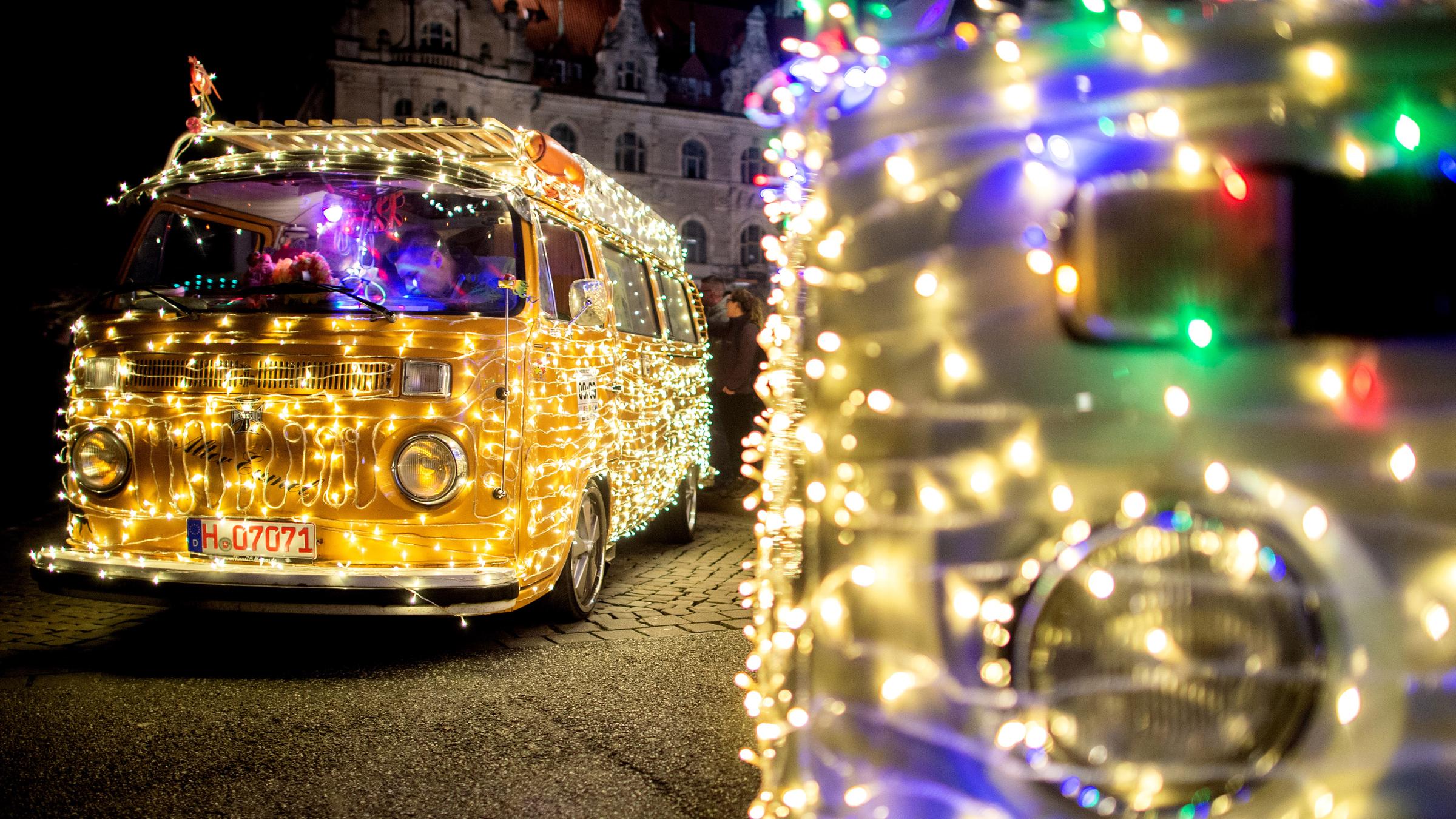 Teilnehmer stehen mit ihrem "Lichter-Bulli", einem gelben Volkswagen t2, auf dem Trammplatz.