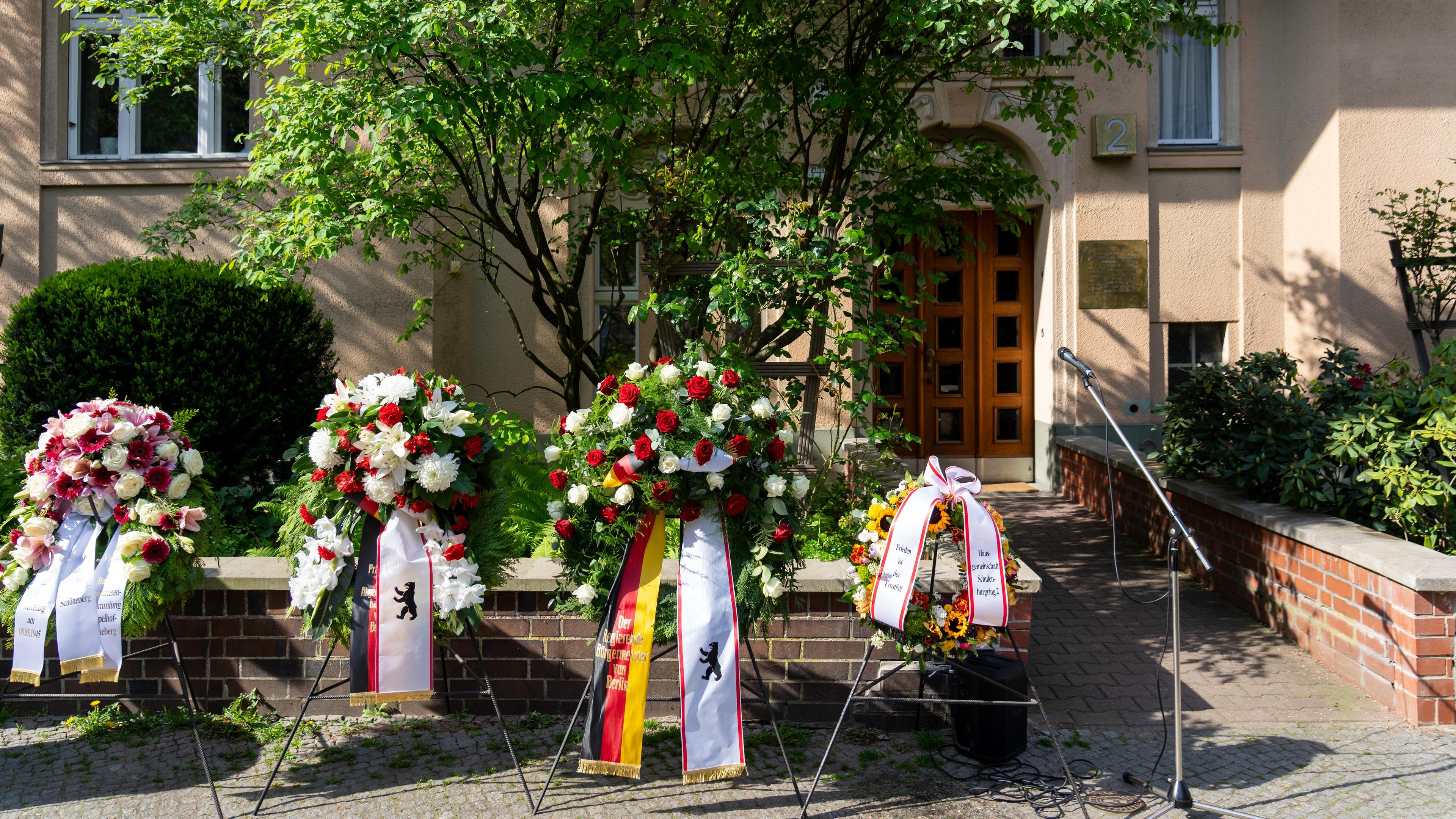  Kränze sind im Rahmen der Gedenkwoche zum 80. Jahrestag des Kriegsendes vor dem Eingang zum Haus Schulenburgring 2 aufgestellt. 