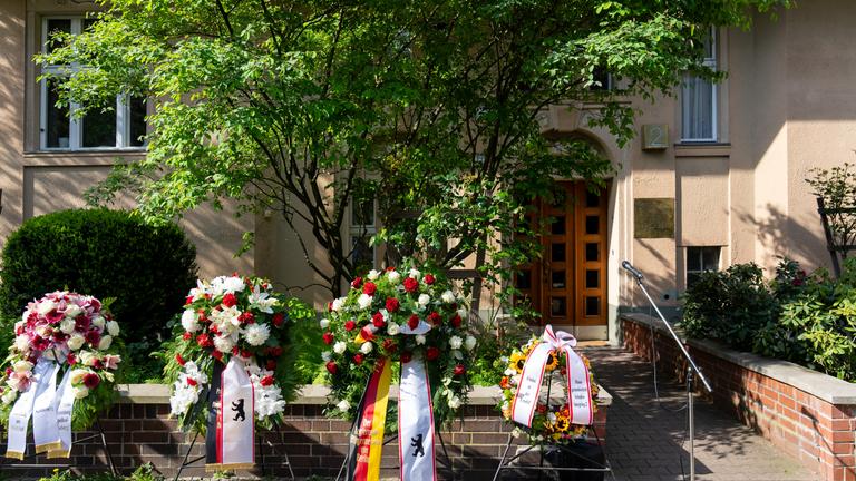  Kränze sind im Rahmen der Gedenkwoche zum 80. Jahrestag des Kriegsendes vor dem Eingang zum Haus Schulenburgring 2 aufgestellt. 