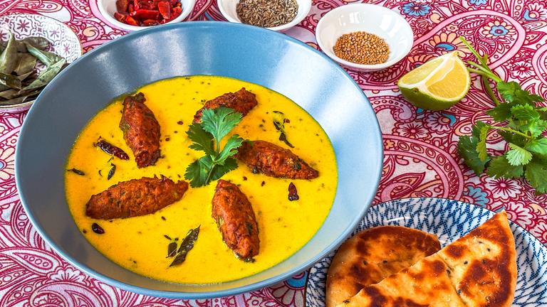 Vegetarische Zwiebel-Krapfen in würziger Joghurtsoße