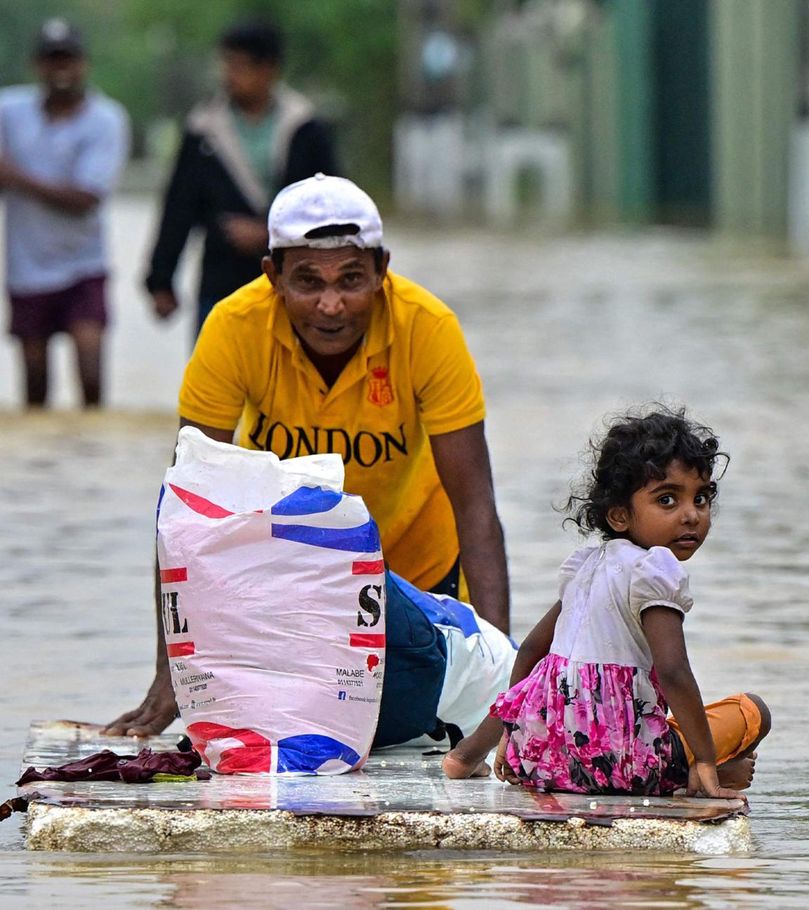 Ambatale, Sri Lanka, 29.11.2025: Ein Mann schiebt ein provisorisches Floß durch überflutete Straßen, während das Land nach Zyklon Ditwah internationale Hilfe anfordert.