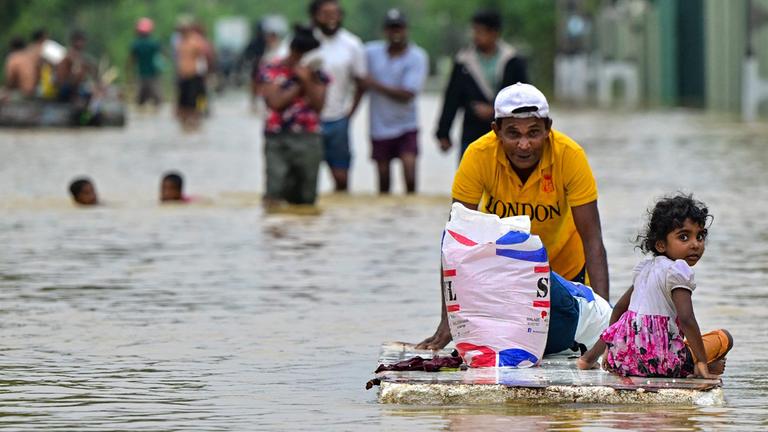 Ambatale, Sri Lanka, 29.11.2025: Ein Mann schiebt ein provisorisches Floß durch überflutete Straßen, während das Land nach Zyklon Ditwah internationale Hilfe anfordert.